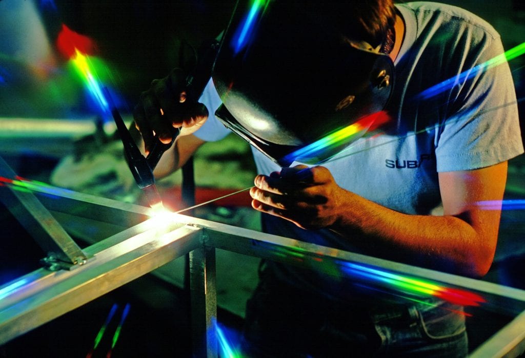 a picture of a welder at work welding part of a steel frame structure