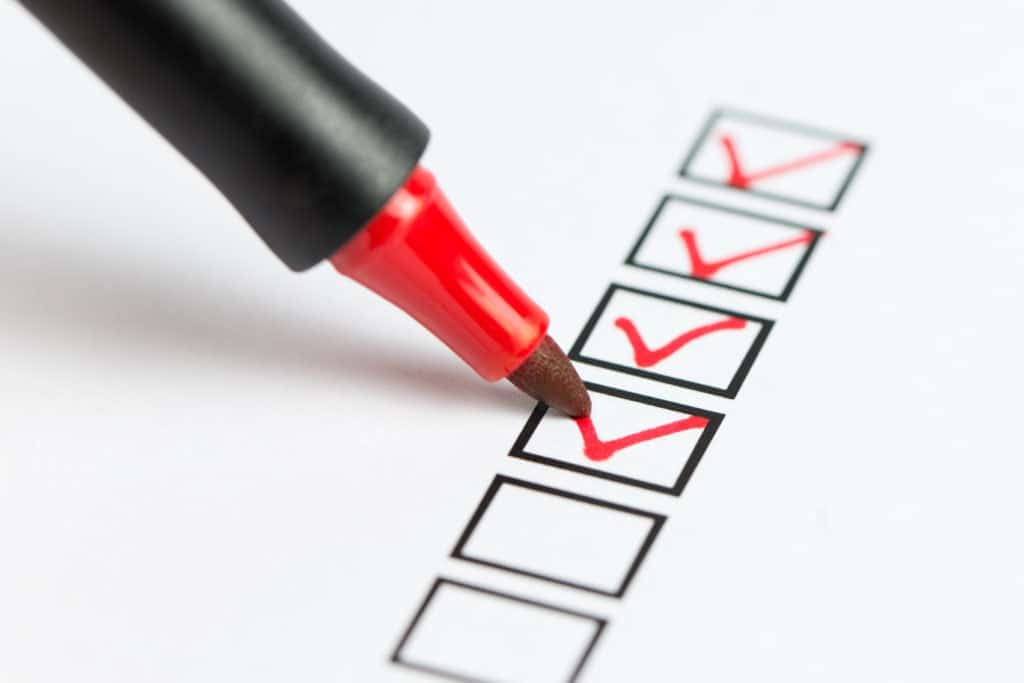 a photo of a checklist being marked with a red pen.
