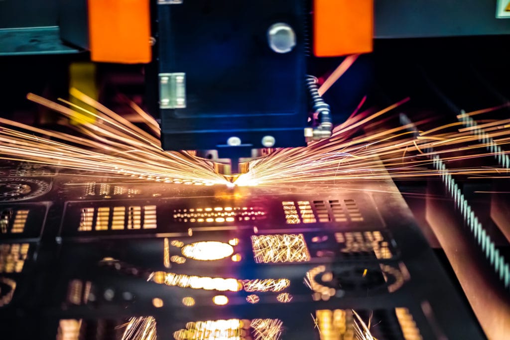 A photo of a CNC machine cutting metal shapes and forms where data is fed from ERP systems.