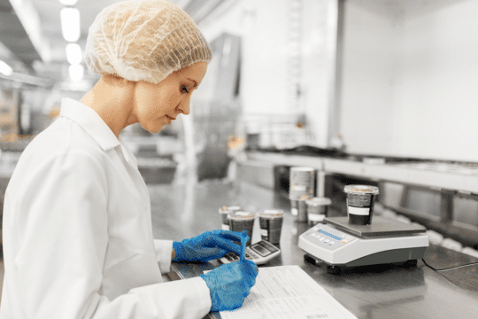 An image of a technician lab testing food samples, a task food and beverage manufacturing ai can make easier.