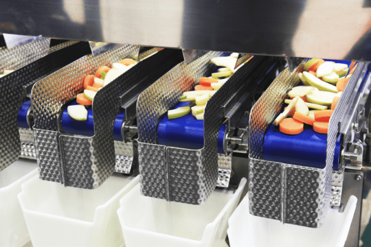 An image of a food processing equipment separating packaged foods, a task food and beverage manufacturing ai can make easier.